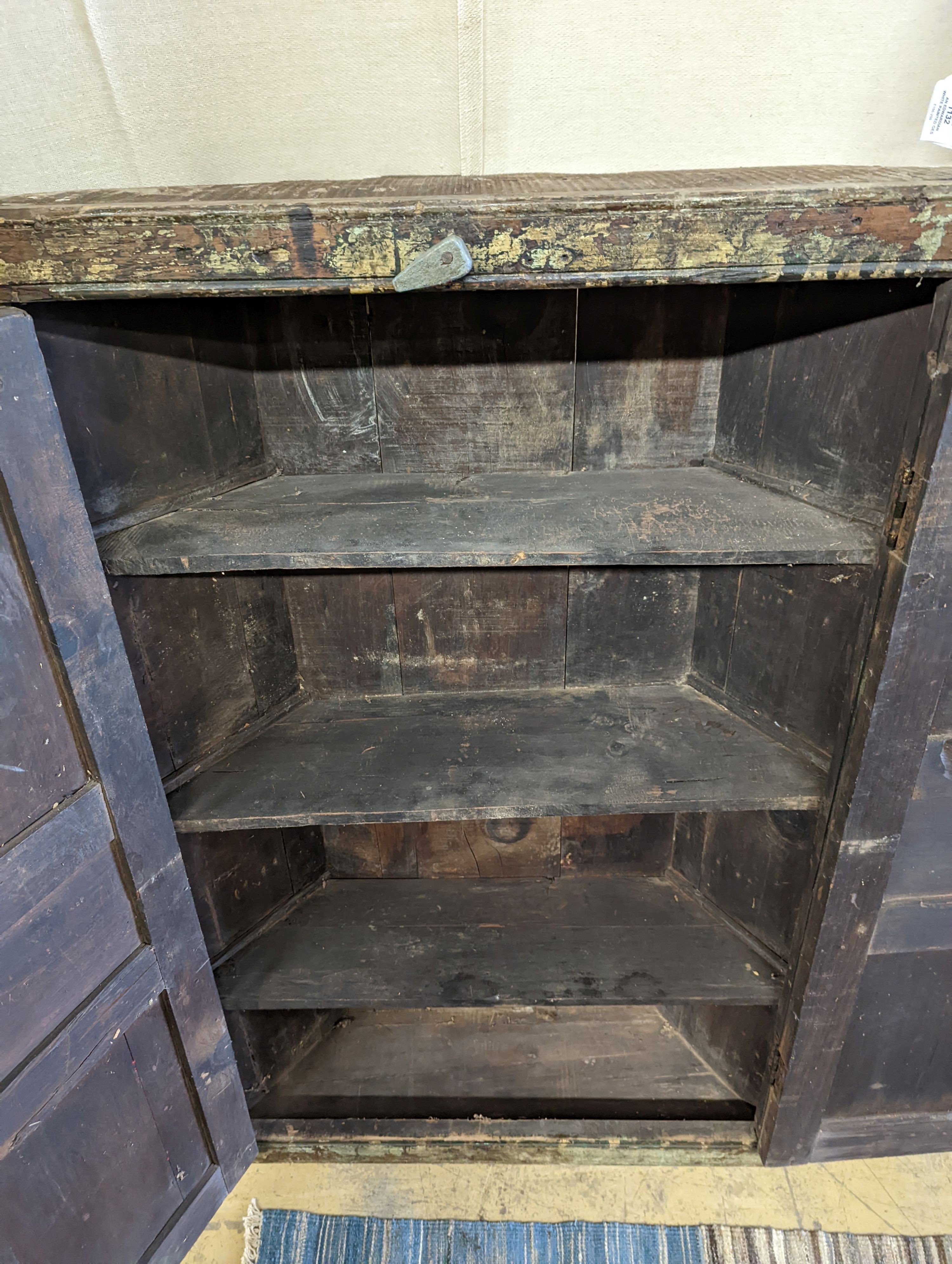 An Afghan painted carved hardwood corner cupboard, width 90cm, height 131cm